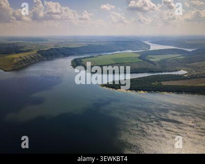 Une prise de vue aérienne capture le fleuve Dniestr serpentant à travers un paysage de collines verdoyantes, de forêts et de champs cultivés en Ukraine. Cette vue grand angle Banque D'Images