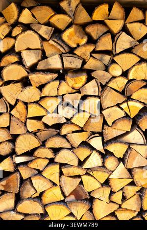 Gros plan de bûches de bois hachées empilées soigneusement dans une grande pile, belle texture de bois de chauffage rustique et motif de bois naturel pour l'arrière-plan sur un Banque D'Images