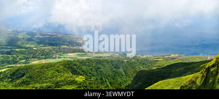 Vue panoramique à couper le souffle sur les pentes verdoyantes, la côte et la mer du Mont Pelée en Martinique, Caraïbes France Banque D'Images