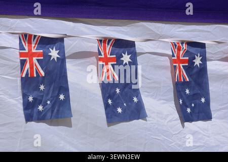Bannière de drapeau australien suspendue comme décoration festive sur un fond de tissu blanc pour une célébration nationale ou un événement public Banque D'Images
