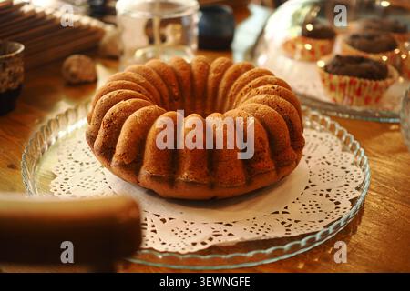 Gâteau fraîchement cuit sur une assiette en verre dans un cadre de café Banque D'Images
