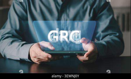 Homme d'affaires tenant smartphone avec texte GRC et icône cible. Gouvernance, gestion des risques et concept de conformité pour la stratégie d'entreprise et la profession Banque D'Images