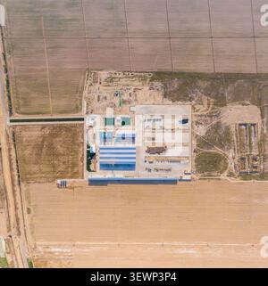 Samarkand, Ouzbékistan - 09 mai 2024 : vue aérienne d'une installation industrielle avec de grands entrepôts, des réservoirs de stockage et des champs agricoles environnants i Banque D'Images