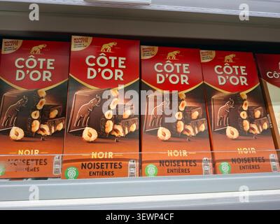 AVIGNON, FRANCE - 31 octobre 2025. Les barres de chocolat noir Côte d’Or avec des noisettes entières sont soigneusement disposées sur une étagère dans une station-service en Provence Banque D'Images