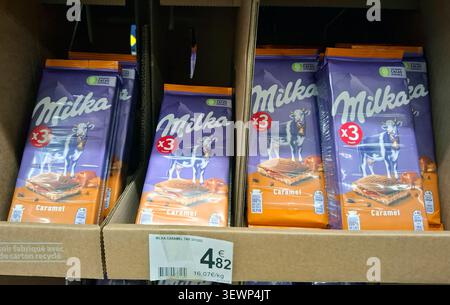 AVIGNON, FRANCE - 31 octobre 2025.les barres de chocolat Milka Caramel sont soigneusement organisées dans une boîte de présentation. L'emblématique vache Milka apparaît sur chaque paquet. Banque D'Images
