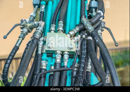 Gros plan des flexibles hydrauliques et des raccords métalliques sur les engins de construction lourds. Banque D'Images