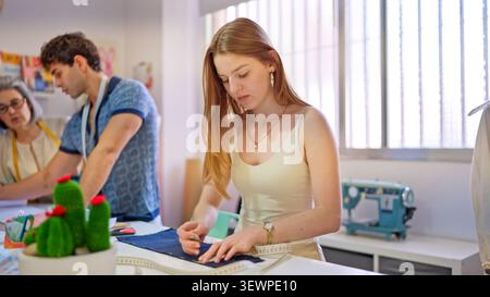 Jeune femme apprenant le design de mode dans un atelier de couture Banque D'Images