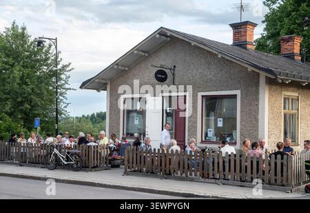 Sièges en plein air dans un café de quartier lors d'une soirée d'été à Malmköping Banque D'Images