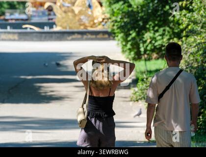 KIEV, UKRAINE - 28 JUIN 2026 : vue arrière d'un jeune homme et d'une jeune femme marchant le long d'un chemin ombragé dans le jardin botanique national M. M. Gryshko. L'annonce femme Banque D'Images