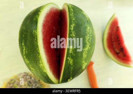 Pastèque rouge juteuse fraîchement tranchée, révélant sa pulpe sucrée et ses graines noires, présentant un fruit d’été sain et rafraîchissant prêt à la consommation Banque D'Images