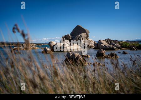 Vue sur les formations rocheuses granitiques uniques de Spiaggia Testa del Polpo entourées d'eaux turquoises et de végétation côtière à la Maddalena, en Sardaigne Banque D'Images