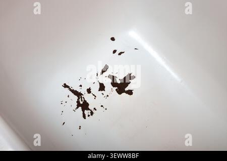 Vue rapprochée d'une baignoire blanche endommagée présentant de l'émail fissuré, de la corrosion du métal et des taches de rouille foncée Banque D'Images