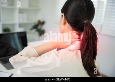 syndromes de bureau, femme massant des douleurs cervicales dues au travail et à l'aide d'un ordinateur, composite numérique d'une colonne vertébrale focalisée de douleurs cervicales et d'épaule symp Banque D'Images