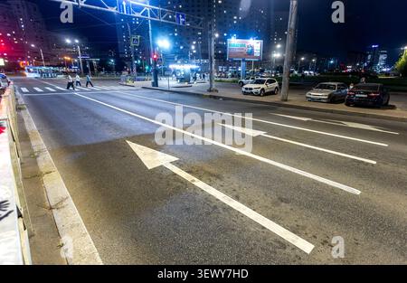 Saint-Pétersbourg, Russie - 11 septembre 2025 : flèches directionnelles et passage à zèbre peints sur la route asphaltée. Panneau fléché sur la route asphaltée Banque D'Images