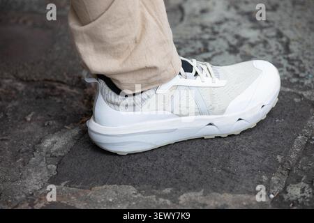 Homme en baskets blanches, vue en grand angle. Banque D'Images