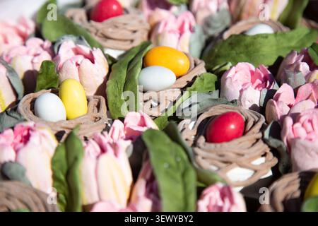 Présentation d'une boulangerie artisanale mettant en avant des œufs en sucre vibrants et des accents floraux Banque D'Images