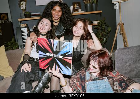 Amis adolescents multiethniques tenant Rock Music Vinyl à la maison Banque D'Images