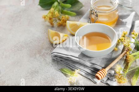 Linden fleurs et miel dans un bol et pot sur une nappe simple Banque D'Images
