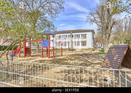 Kitawo Kita Farbklecks, jardin d'enfants avec équipement de jeu coloré et un bâtiment de deux étages en arrière-plan, à Magdebourg, Saxe-Anhalt, Banque D'Images