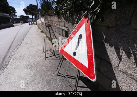 Panneau d'avertissement de travaux routiers temporaires placé sur le bord de la route. Contexte de sécurité routière illustrant les dangers de la construction transport et conduite prudence. Banque D'Images