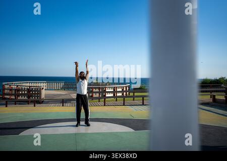 Homme faisant de l'entraînement sportif sur un terrain de basket-ball extérieur Banque D'Images