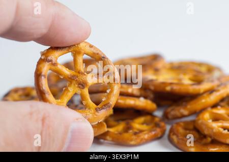 Roues UTZ Classic Pretzel tenues à la main. Gros plan. Banque D'Images