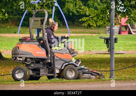 Femme professionnelle chargée de l'entretien du parc et de l'entretien du sol qui utilise une tondeuse Husqvarna avec protection auditive dans le Brunnsparken Ronneby Sweden Outdoor Wor Banque D'Images