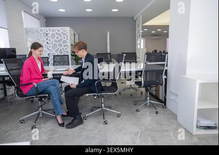 Les collègues boivent un café et discutent pendant une pause au bureau. Banque D'Images