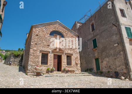 Verezzi, une charmante rue pavée qui descend dans un village historique, encadrée par des murs en pierre sèche Banque D'Images