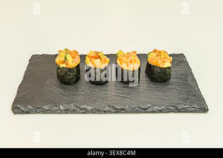 Vue centrale d'un repas qui comprend une généreuse portion de saumon frais, une généreuse quantité de riz et une sélection de sushis assortis sur le côté Banque D'Images
