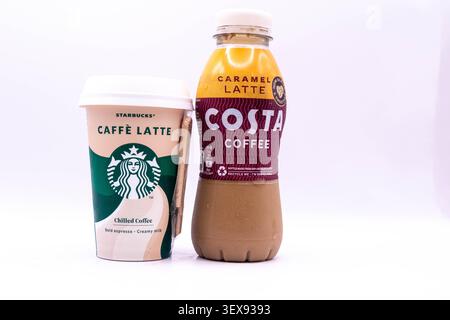 Londres, Royaume-Uni, 24 juin 2026 :- Une vue d'Un Costa Caramel Latte et Starbucks Caffe Latte réfrigéré, café réfrigéré, contre un dos blanc Banque D'Images