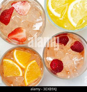 Boissons pétillantes infusées de fruits colorés avec glaçons dans des verres vue de dessus ensemble de rafraîchissement d'été Banque D'Images