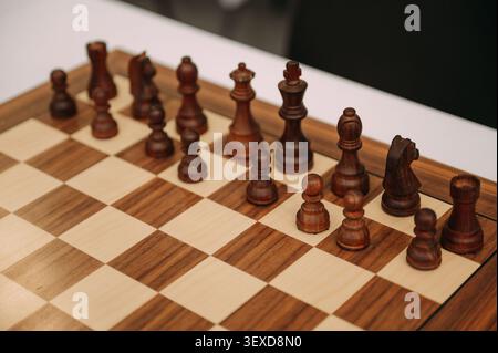 Pièces d'échecs en bois sur échiquier pendant le jeu stratégique Banque D'Images