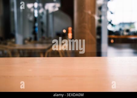 Plateau en bois avec vue floue sur le restaurant ou le café avec chaise et fond de table Banque D'Images