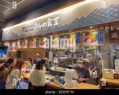 Intérieur d'un restaurant de fruits de mer japonais moderne avec menus, personnel et clients commandant des plats traditionnels. Fukuoka, Japon - 2 novembre 2025. Banque D'Images