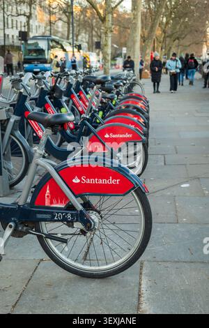 Rangée de vélos de location Santander rouges garés dans une station d'accueil de la ville à Londres, présentant le partage de vélos urbains, le transport durable, les navetteurs et tou Banque D'Images