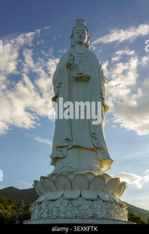 Statue de la Dame Blanche Bouddha à Chua Linh Ung sur la péninsule de son Tra, Da Nang, Vietnam, se levant contre le ciel bleu et les nuages. Banque D'Images