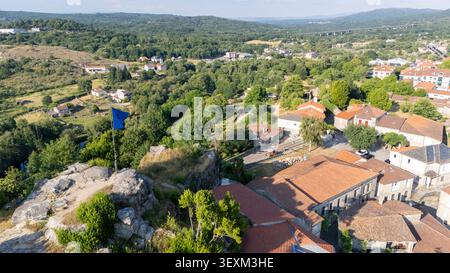 Ville rurale espagnole d'Allariz nichée dans une vallée verdoyante et une forêt, vue d'en haut avec un drapeau bleu agitant sur une colline rocheuse Banque D'Images