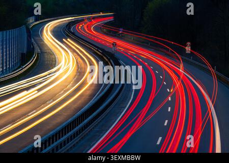 Autobahn A46 allemande au crépuscule du soir à Iserlohn Sauerland depuis le pont du centre-ville, longue exposition de temps avec des traces lumineuses courbées des feux de voiture qui passent Banque D'Images