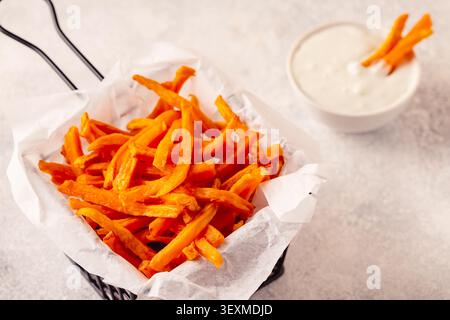 Frites de patates douces dans un panier avec sauce au fromage bleu. Banque D'Images