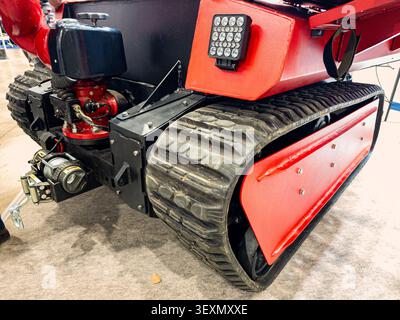 Une vue rapprochée d'un véhicule terrestre sans pilote à chenilles (UGV) moderne conçu pour les missions tactiques, militaires ou de sauvetage, doté d'un châssis rouge durable Banque D'Images