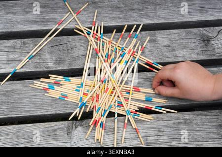 Bâtons d'encens dans la main d'un enfant sur un fond en bois Banque D'Images