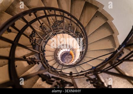 Une perspective abstraite spectaculaire de haut en bas d'un escalier en colimaçon en pierre historique avec une balustrade en fer forgé ornée à l'intérieur de la Basilique Stephen, a fa Banque D'Images