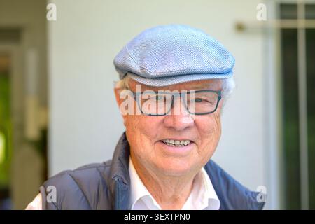 Portrait d'un homme senior souriant amical portant des lunettes et une casquette dans une lumière naturelle douce. Image authentique du mode de vie des personnes âgées représentant le vieillissement actif, Banque D'Images