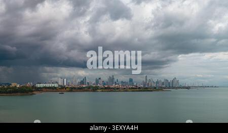 Vue aérienne de l'horizon moderne de Panama City sous les nuages sombres dramatiques de tempête au-dessus de l'océan Pacifique à Panama, Provincia de Panama, Panama. Banque D'Images