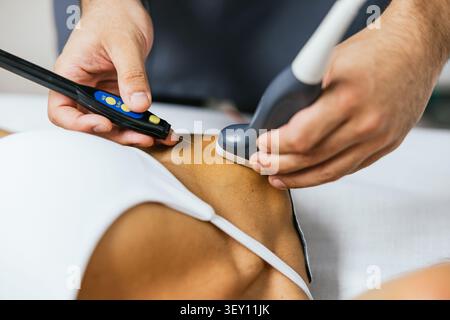 Physiothérapeute pratiquant l'aiguilletage à sec et la thérapie par ultrasons Banque D'Images
