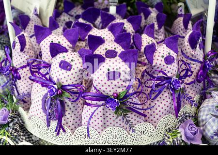 Décorations de porc en tissu violet fait à la main dans le panier Banque D'Images