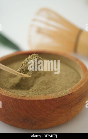 Poudre de matcha dans un bol en bois avec fouet en bambou Banque D'Images
