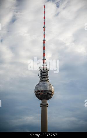 Vue rapprochée de la Tour de télévision de Berlin (Fernsehturm) avec son observatoire sphérique et son antenne s'élevant dans un ciel nuageux. Monument urbain emblématique archi Banque D'Images