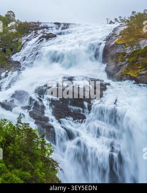 L'impressionnante cascade Nykkjesoyfossen (Nykkjesøyfossen) descend puissamment un flanc de montagne accidenté près de Kinsarvik dans le comté de Vestland, en Norvège. S Banque D'Images
